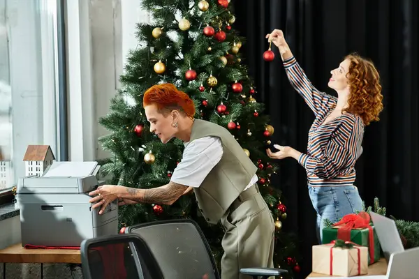 A cheerful moment of young colleagues enhancing their workspace with festive decorations. — Stock Photo