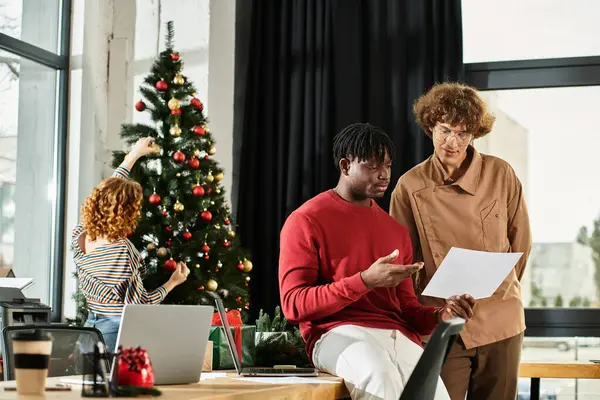 Un gruppo di colleghi gode di una allegra celebrazione di Natale nel loro ufficio. — Foto stock