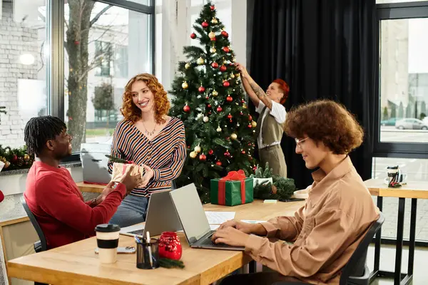 In a lively office, young employees gather to celebrate Christmas with decorations and gifts. — Stock Photo