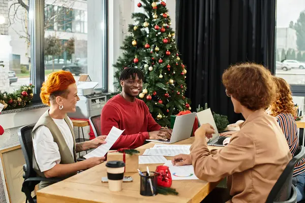 Coworkers share laughter and festive cheer while enjoying Christmas celebrations at work. — Stock Photo