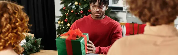 Os colegas de trabalho reúnem-se alegremente em um escritório decorado, trocando presentes pela alegria de Natal. — Fotografia de Stock