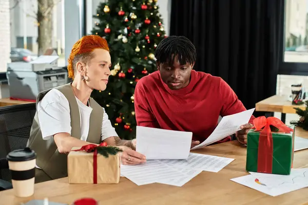 A diverse group of coworkers exchange gifts and enjoy the holiday spirit in an office. — Stock Photo