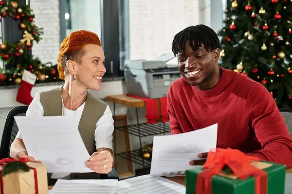 Colleagues share laughter and festive cheer while exchanging gifts during a holiday celebration. — Stock Photo