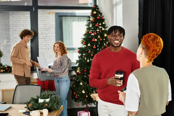 I colleghi festivi apprezzano lo spirito natalizio mentre condividono sorrisi e bevande al lavoro. — Foto stock