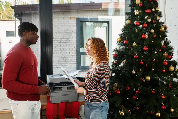 Dois colegas de trabalho compartilham risos e espírito de férias enquanto se preparam para o Natal em seu escritório. — Fotografia de Stock