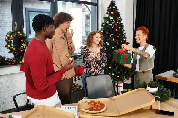 Eine Gruppe von Mitarbeitern genießt Pizza, Lachen und Geschenke während ihrer Weihnachtsfeier. — Stock Photo