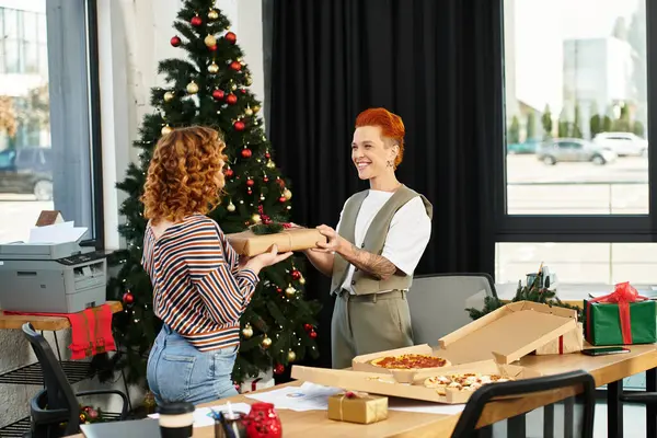 Coworkers exchange gifts while enjoying the festive spirit of Christmas in the office. — Stock Photo