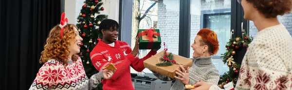 Colleagues gather around to exchange gifts and enjoy the holiday spirit in the office. — Stock Photo