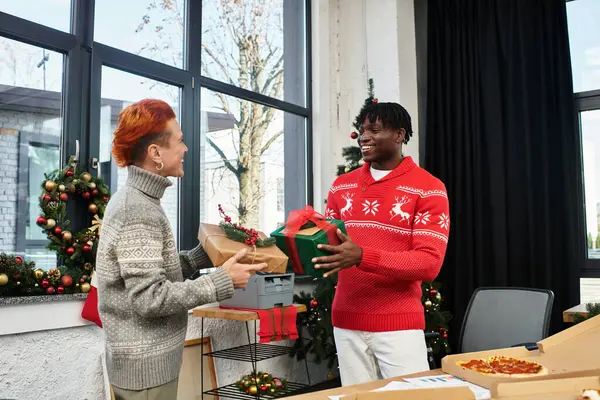 Colegas trocam presentes e compartilham sorrisos durante uma alegre celebração de Natal no trabalho. — Fotografia de Stock