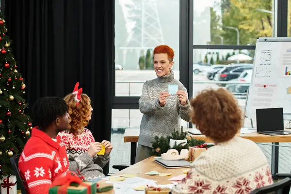 A group of young coworkers enjoy a festive Christmas celebration with laughter and gift exchanges. — Stock Photo