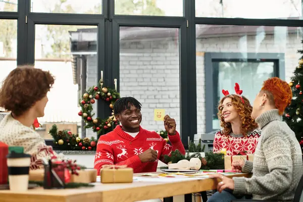 A group of young coworkers shares laughter and joy while celebrating Christmas in the office. — Stock Photo