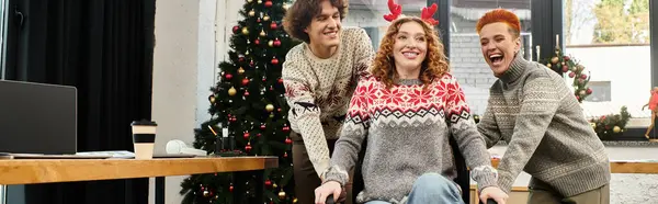 Three coworkers joyfully celebrate Christmas together in a decorated office environment. — Stock Photo