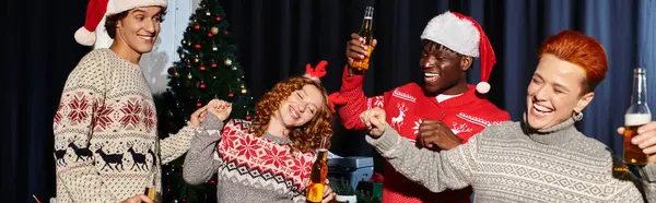 Jeunes collègues en chandails festifs célèbrent joyeusement les vacances avec des boissons. — Photo de stock