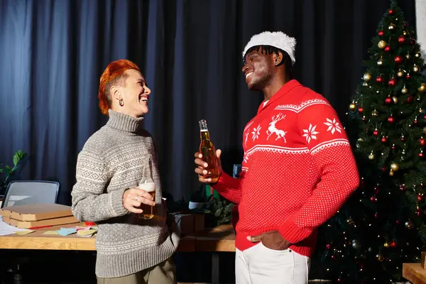 Colleagues share laughter and drinks while enjoying their Christmas party at work. — Stock Photo
