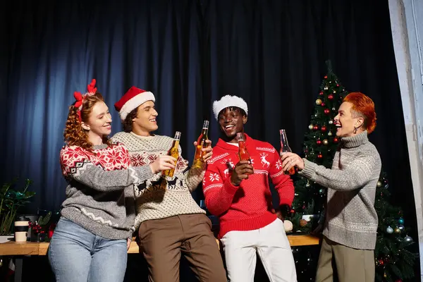 Four joyful coworkers clink glasses while celebrating Christmas in their office. — Stock Photo