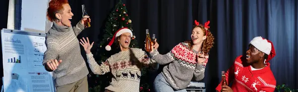 Um grupo animado de jovens colegas de trabalho desfruta de uma alegre celebração de Natal juntos no escritório. — Fotografia de Stock