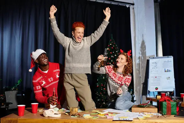 I cospiratori festeggiano con entusiasmo il Natale in ufficio con bevande e risate. — Foto stock