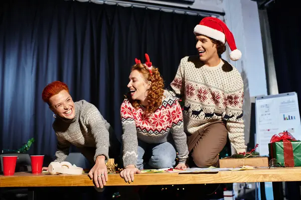 Un divertente gruppo di giovani colleghi festeggia il Natale in maglioni festivi. — Foto stock
