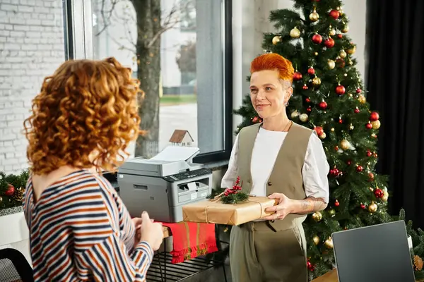 Coworkers exchange gifts and celebrate Christmas joyfully in a decorated office space. — Stock Photo