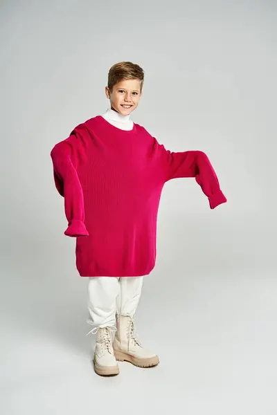 A boy enjoys the winter in a large, warm sweater with a cheerful expression. — Stock Photo