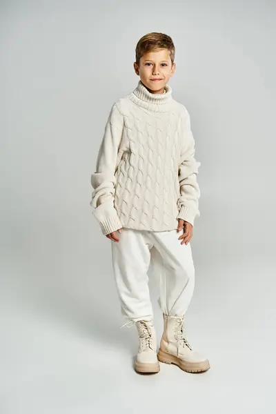 Un ragazzo allegro si trova con fiducia in caldo, accogliente abbigliamento invernale, irradiando felicità. — Foto stock