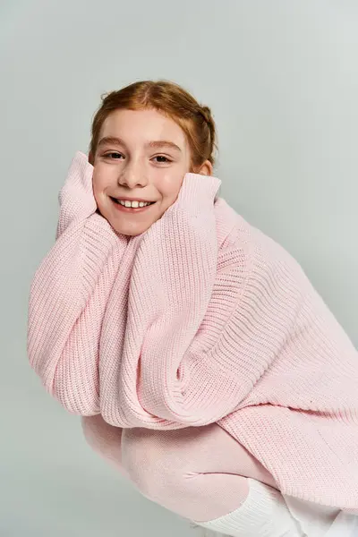 A joyful girl enjoys winter wearing a soft pink sweater, radiating warmth and happiness. — Stock Photo