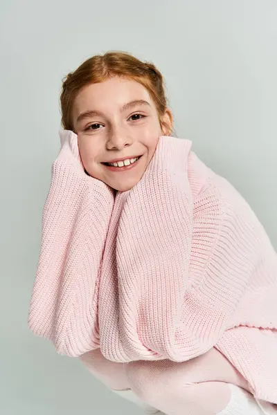 Una ragazza felice vestita con un morbido maglione rosa trasuda calore e allegria durante l'inverno.. — Foto stock