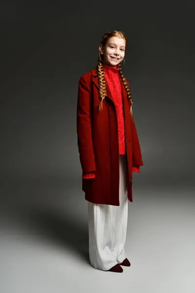 A cheerful girl dressed in cozy winter clothing stands confidently, radiating warmth and joy. — Stock Photo