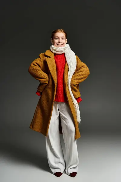 A joyful girl dressed in winter attire stands confidently in a cozy indoor setting. — Stock Photo