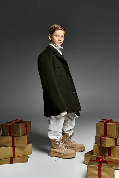 The cheerful boy displays a sense of style wearing warm clothing, surrounded by wrapped presents. — Stock Photo
