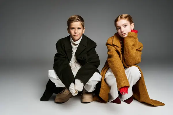Zwei warm gekleidete Kinder im stylischen Winteroutfit genießen einen gemütlichen Moment zusammen im Haus. — Stockfoto