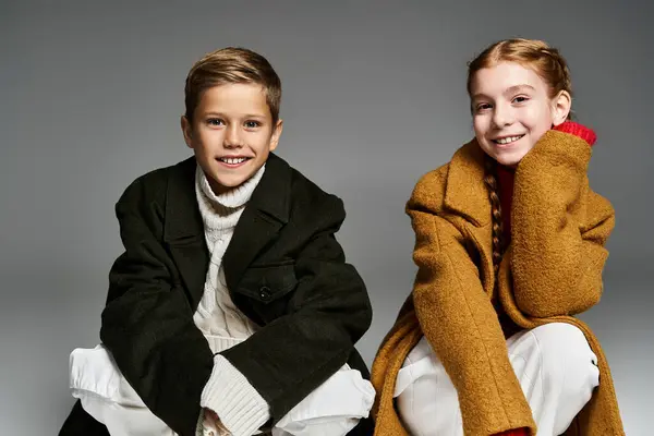 Two children showcase their cozy winter outfits, exuding warmth and joy during winter days. — Stock Photo