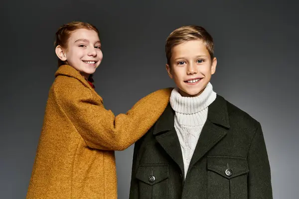 Two children wearing warm winter clothes share a delightful moment together indoors. — Stock Photo