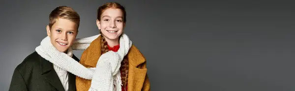 Two joyful kids bundled in cozy winter clothing share a cheerful moment in the cold. — Stock Photo