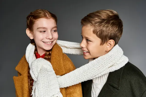 Two children share a joyful moment wearing warm winter clothes with playful expressions. — Stock Photo