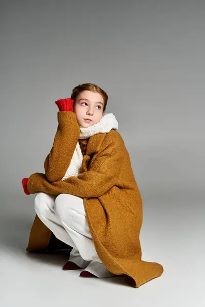 A girl dressed warmly in a bright coat and scarf reflects quietly on a chilly winter afternoon. — Stock Photo