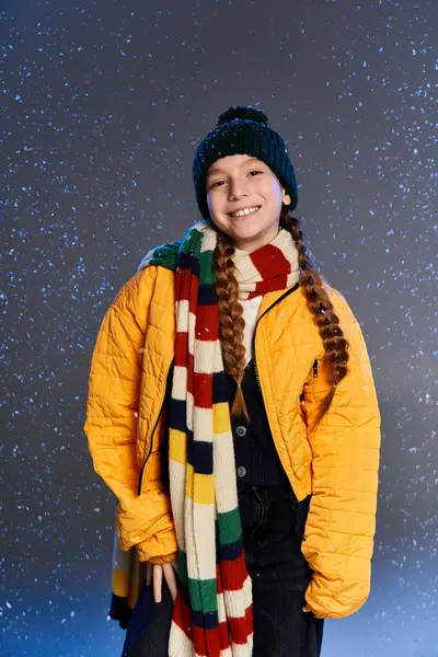 A young girl dressed warmly in bright winter clothing stands happily in the snow. — Photo de stock