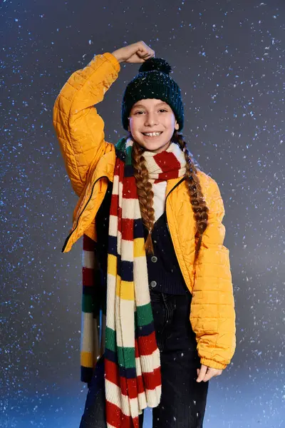 A cheerful girl in bright winter clothing enjoys the magical snowfall with excitement. — Stock Photo