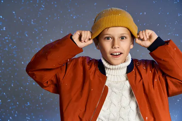 A young boy is excited, clad in warm clothing, playfully interacting with falling snowflakes. — Stock Photo