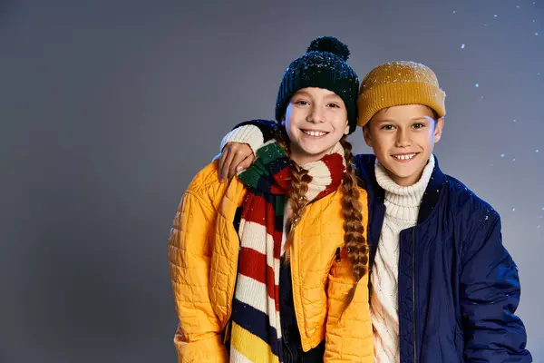 Happy kids in vibrant winter outfits share a joyful moment in a playful snowy atmosphere. — Stock Photo