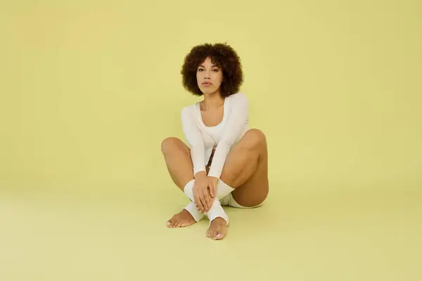 A young Black woman sits gracefully in stylish underwear — Stock Photo