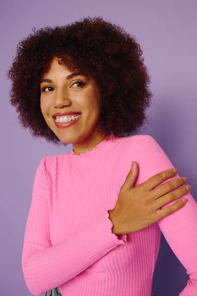 Uma jovem mostra sua emoção com um sorriso brilhante enquanto vestida com roupas rosa casuais. — Fotografia de Stock