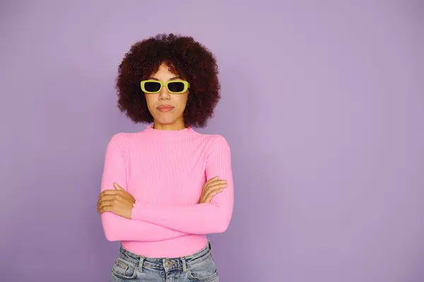 Una joven afroamericana vestida de rosa casual muestra emociones fuertes con un vibrante telón de fondo. — Stock Photo