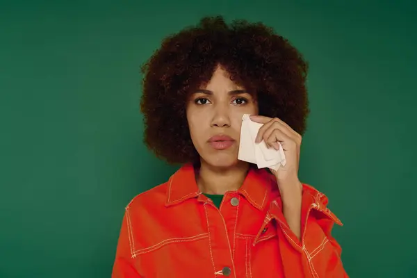 Una hermosa joven muestra sus sentimientos mientras sostiene un pañuelo, rodeada de vibrantes tonos verdes. — Stock Photo