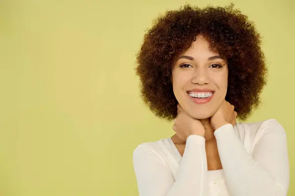 A young African American woman in underwear radiates joy while standing against a lively yellow background. — Stock Photo