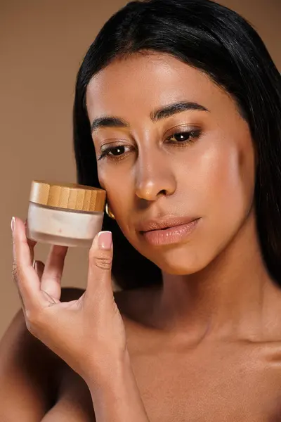 A beautiful African American woman demonstrates her skincare routine in a studio. — Stock Photo