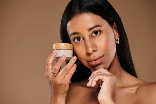 A woman presents a skincare product while promoting beauty diversity in a studio setting. — Stock Photo