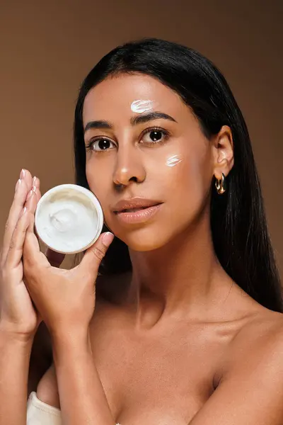 A confident African American woman highlights her skincare routine while posing in a studio. — Stock Photo