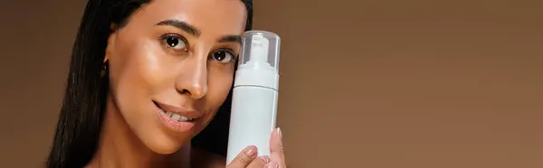 A stunning African American woman demonstrates a body care routine in a well-lit studio setting. — Stock Photo