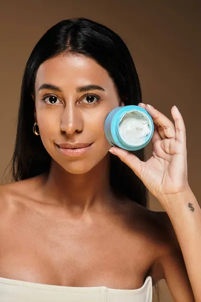 A woman highlights her skincare routine in a studio setting, focusing on body care. — Stock Photo